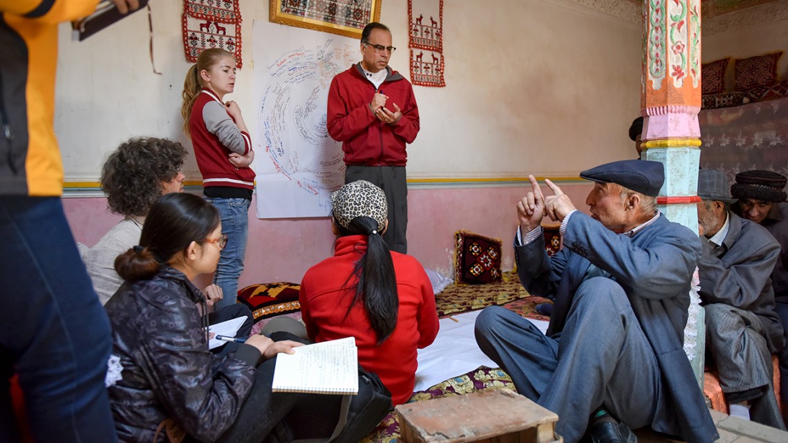 Professor Karim-Aly Kassam meets, standing at center, talks with herders and farmers in Post Doct Village in Xinjiang, China.