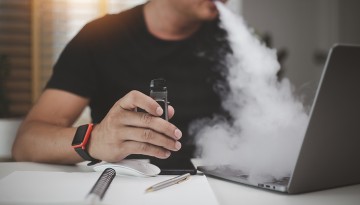 photo of person vaping while using a laptop