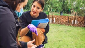 Cheyenne Reuben-Thomas, a doctoral student in the field of ecology and evolutionary biology, does field work on land management.
