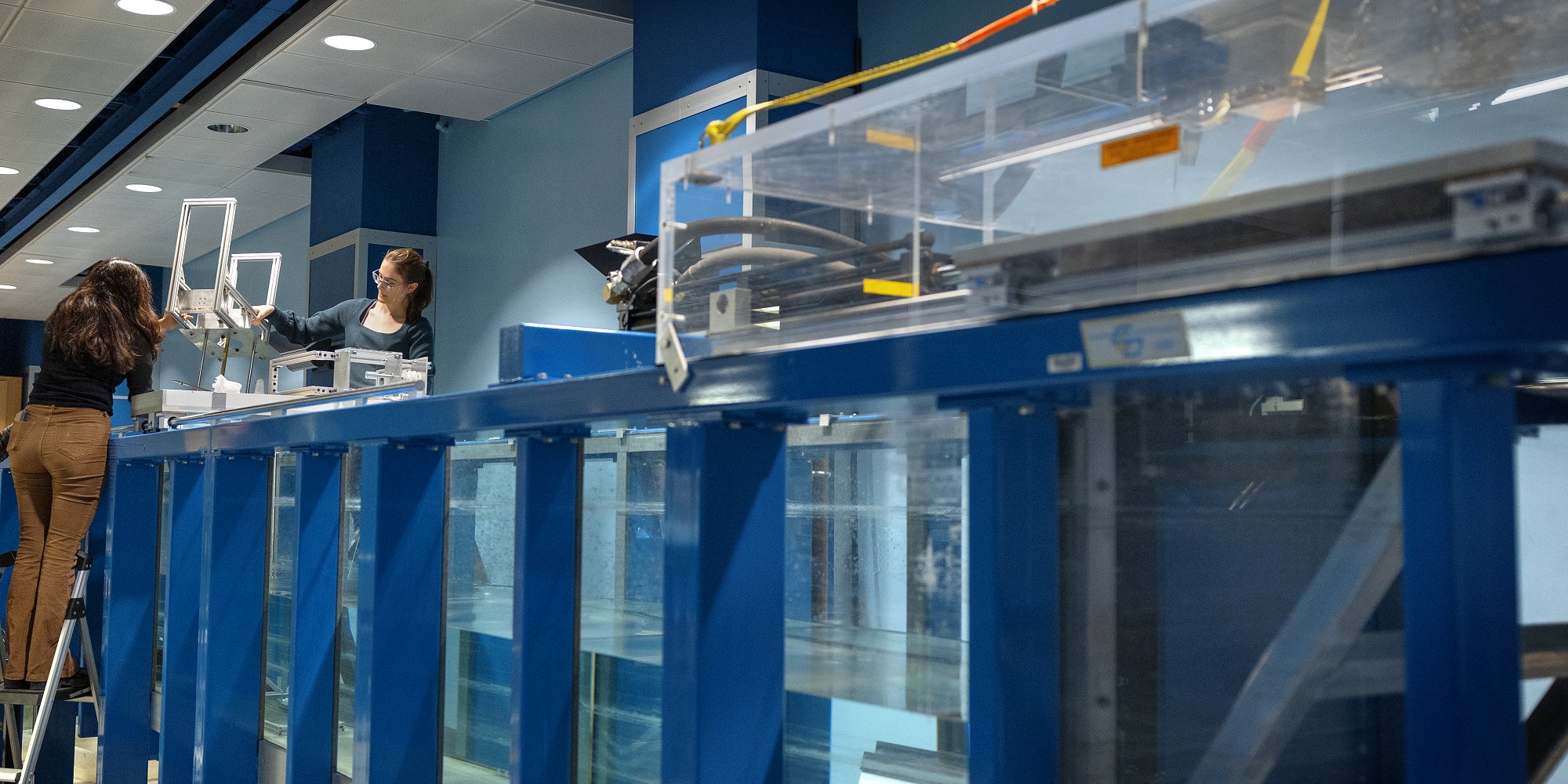 Kavya Mittha ’26, left, and Aisha Brundan ’25 prepare to submerge and test their bobbing buoy wave energy converter at the DeFrees Hydraulics Lab.