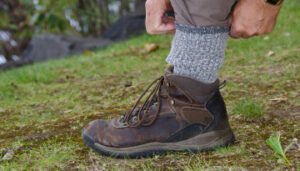 Hiker pulling socks up over pant leg
