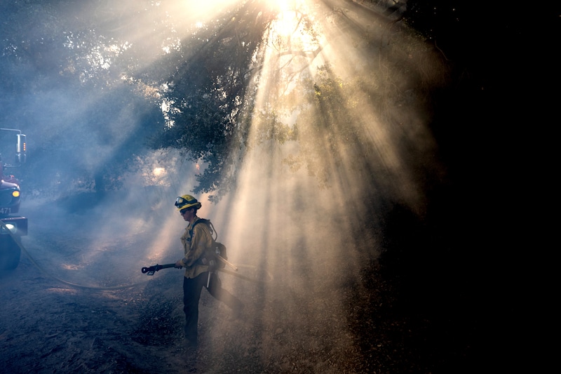A firefighter walks through smoke while battling the Mountain Fire on Thursday, Nov. 7, 2024, in Santa Paula, Calif. Children will experience more smoke-laden days because of increasing wildfires. (Noah Berger | AP)AP