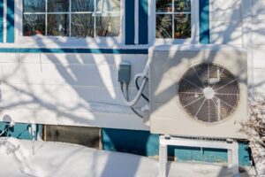 Electric heatpump on the side of a house during winter