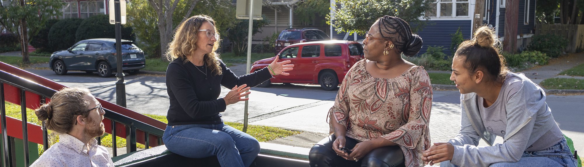 Alistair Hayden and Rebecca Morgenstern Brenner chat with Chavon Bunch, executive director of the Southside Community Center and Kayla Matos, deputy director of Southside Community Center, outside the Southside Community Center in Ithaca, New York. (Noël Heaney, UREL)