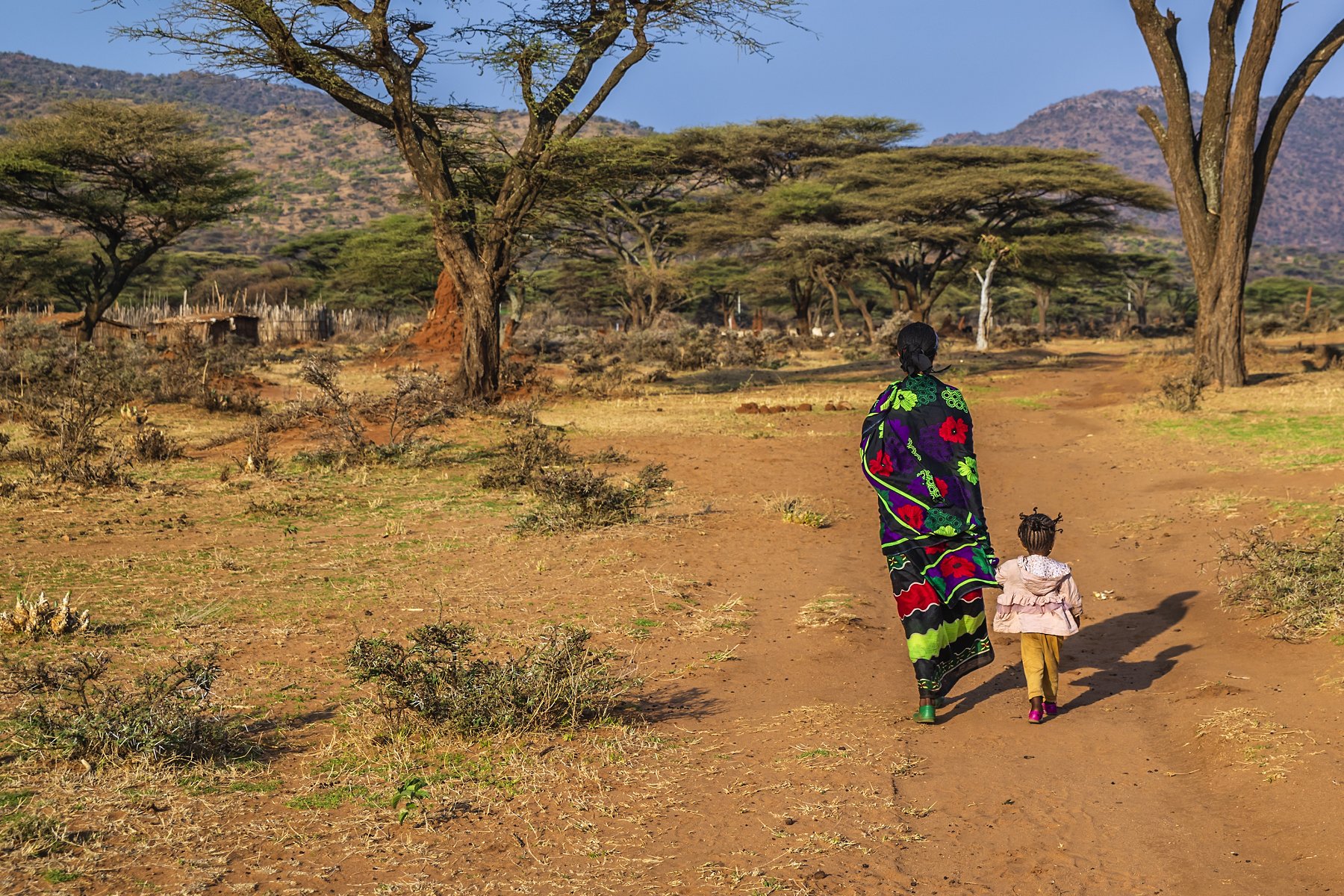 Woman from Borana tribe walking with her child in southern Ethiopia, Africa. The Borana Oromo are a pastoralist tribe living in southern Ethiopia and northern Kenya.